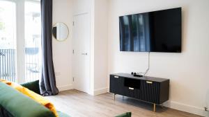 a living room with a flat screen tv on a wall at Beautiful Flat 2-Mins away from Rochester Station in Rochester