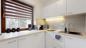 a kitchen with white cabinets and a window at Studio Fibra Lungo in Rybnik