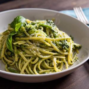 a white bowl of pasta with broccoli and greens at Newsy Inn in Hithadhoo