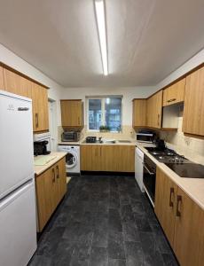 a large kitchen with wooden cabinets and white appliances at Rotherham Meadowhall in Rotherham