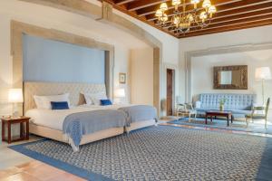 a bedroom with a large bed and a living room at Pousada Castelo de Palmela in Palmela