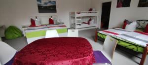 a room with two beds and a red table and chairs at zu den blauen Schwertern in Meißen