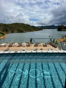 a swimming pool with chairs and a view of a river at Roka Hotel in Guatapé +49 photos