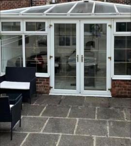 a conservatory with glass doors and a table and chairs at Rotherham Meadowhall in Rotherham