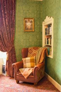 a living room with a chair and a book shelf at Preston House in Abbeyleix