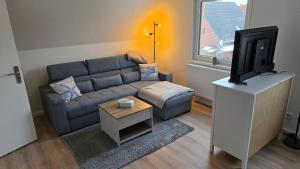 a living room with a couch and a tv at Meehr-Laboe in Laboe +20 photos