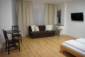 a living room with a couch and a table at HANOSAN Apartments Familienhaus 4 Zimmer 125 m2 in Garbsen