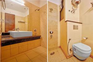 two pictures of a bathroom with a toilet and a sink at FabHotel Smart Inn-1 in Gurgaon +18 photos