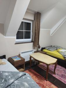 a room with two beds and a table and a window at WEGA Star Apartmani in Brzeće
