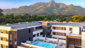 a building with a swimming pool and mountains in the background at Luxury Apartment Unit 111 Le Jardin in George