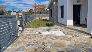 a garden with a blue fence and a stone patio at Villa Sofia in Kalives Poligirou