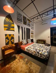 a bedroom with a bed and a chair at La Villa Saint Jean in Cotonou