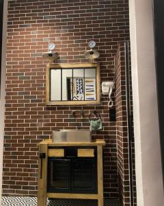 a bathroom with a sink and a mirror on a brick wall at La Villa Saint Jean in Cotonou +51 photos