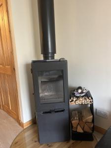a stove in a room with a pile of wood at Hopeman Cottage in Hopeman