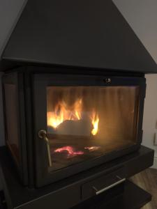 a fireplace with a fire in it in a room at Casa Negra in Moralzarzal