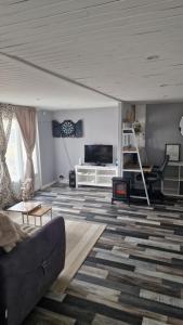 a living room with a couch and a tv at Chalet in Saint-Anthème