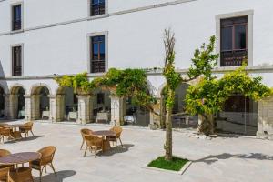 a courtyard with tables and chairs in front of a building at Pousada Castelo de Palmela in Palmela