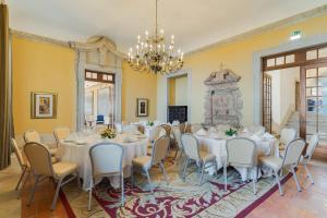 a large room with tables and chairs and a chandelier at Pousada Castelo de Palmela in Palmela