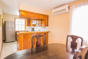 Una cocina con una mesa con sillas y un refrigerador. en Casa Brisa Guest House, en San Pedro