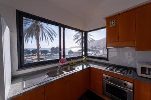 a kitchen with two sinks and two large windows at Apartamentos Amarelo in Caniçal