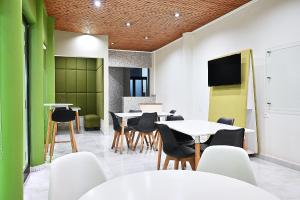 a dining room with tables and chairs and a tv at Ganalé Hôtel in Dakar