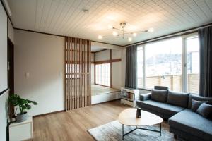 a living room with a couch and a table at 禅ーZen Villa Hakodate in Hakodate