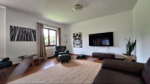 a living room with a couch and a flat screen tv at Gästehaus FaRitz in Knittelfeld