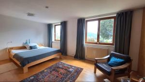 a bedroom with a bed and a chair and window at Gästehaus FaRitz in Knittelfeld