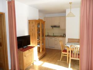 a kitchen with a table and a dining room at Appartamenti Stauderhof in Villabassa