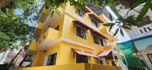 a yellow building with windows on a street at Coastal Calm Inn in Fort Kochi
