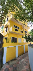 a yellow building with a fence in front of it at Coastal Calm Inn in Fort Kochi +189 photos