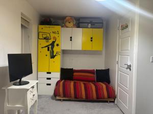 a room with a bed and a tv and a door at AdB in Hemel Hempstead
