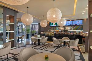 a restaurant with tables and chairs and a bar at Park Rotana Abu Dhabi in Abu Dhabi