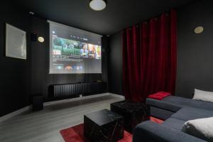 a living room with a couch and a large screen at Ciné Suite - Arras 5 guests in Arras