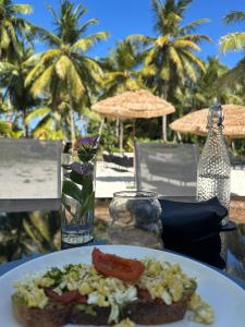 a plate of food on a table with palm trees at Ambra Maldives in Thoddoo
