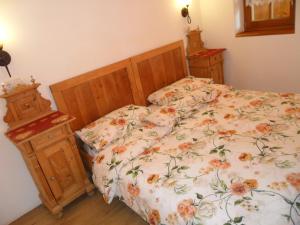 a bedroom with a bed with a floral bedspread at Appartamenti Stauderhof in Villabassa