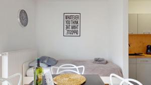 a room with a bed with a table and chairs at Apartament Fibra Cortado in Rybnik