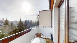 a balcony with a chair and a view at Apartament Fibra Cortado in Rybnik