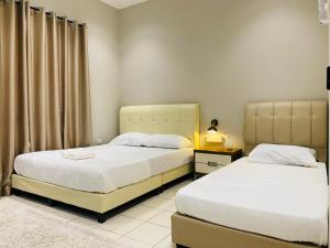 a bedroom with two beds and a window at Hanah Home Pagoh in Pagoh