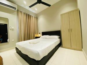 a bedroom with a large bed and a wooden cabinet at Hanah Home Pagoh in Pagoh