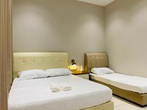 a bedroom with two beds with white sheets and slippers at Hanah Home Pagoh in Pagoh +18 photos