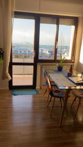 a dining room with a table and a view of a harbor at Blue Zen beachfront apartment in Civitanova Marche
