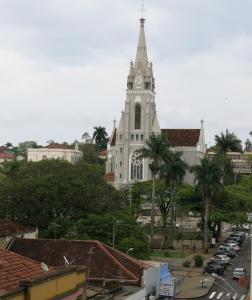 a church with a clock tower in a city at Hotel Jaú by Easy Hotéis in Jaú