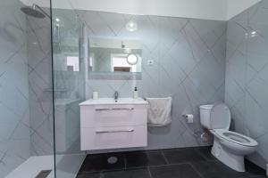 a bathroom with a toilet and a sink and a shower at Apartamentos Amarelo in Caniçal +34 photos