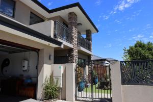 a house with a gate and a fence at Midby's Elegant Guesthouse - 2 En-suite Rooms & 2 Rooms with Shared Bathroom in Perth