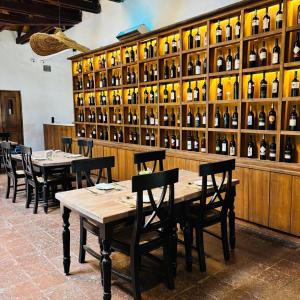 a dining room with tables and bottles of wine at Hotel Villa el Descanso in Curicó