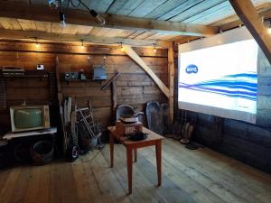 a projection screen in a room with a tv at Wehikuł Czasu in Jędrzejówka