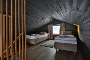 a attic room with two beds and a window at Riekko Lodge in Äkäslompolo