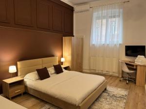 a bedroom with a bed and a desk and a television at Corvin Guesthouse in Hunedoara