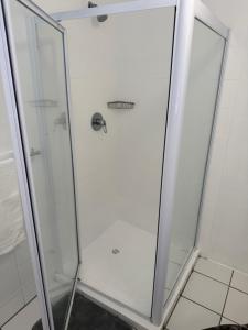 a shower with a glass door in a bathroom at The Garden Den in Nelspruit +8 photos